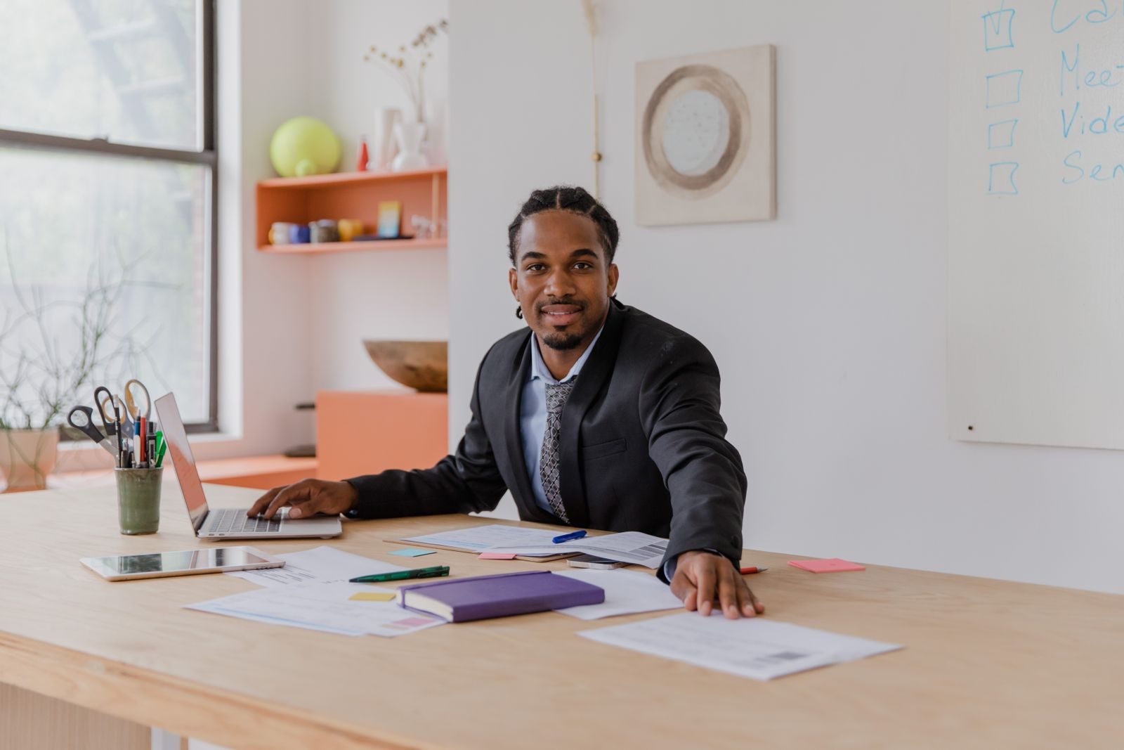 A small business owner working with documents and a laptop at a desk