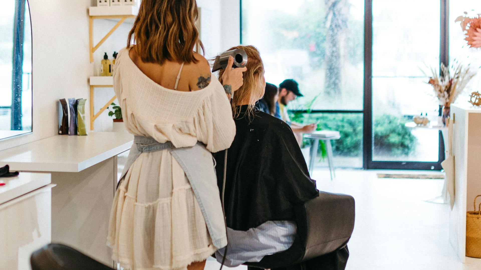 Client checking an appointment on a phone while a small business owner confirms the booking