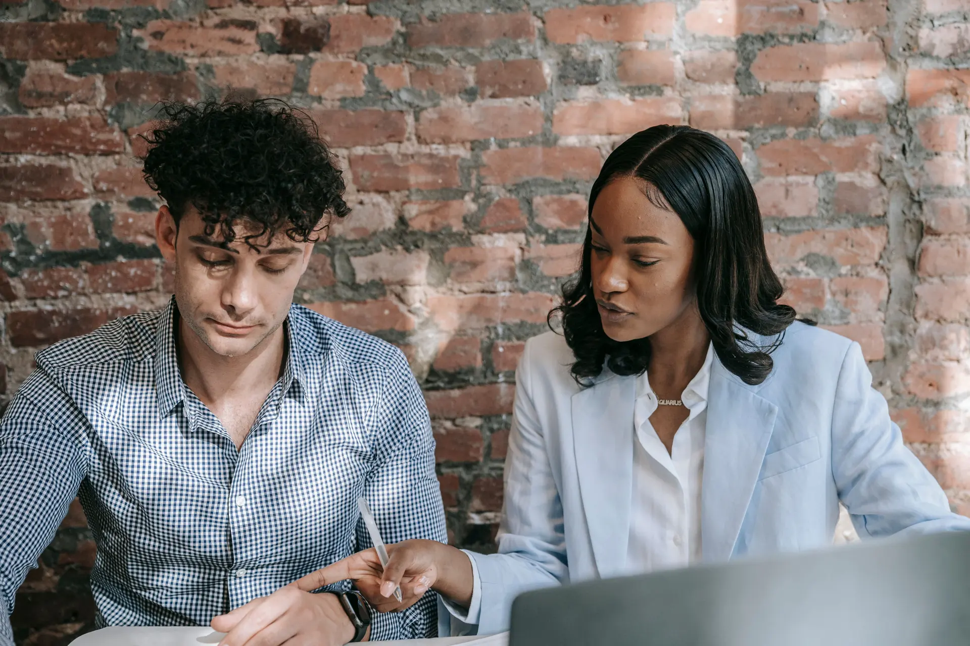 Two people looking at a website on a laptop screen together