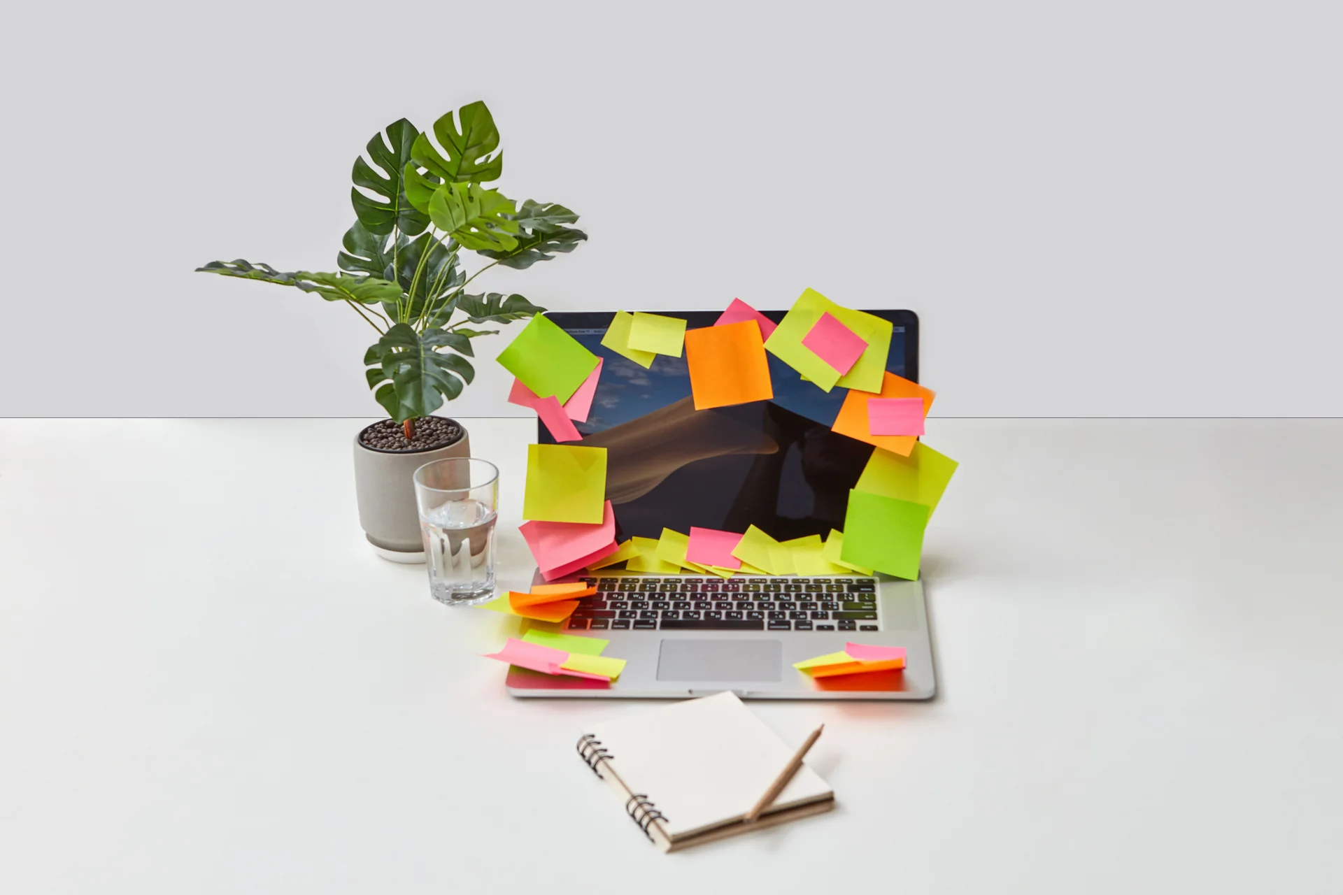 A desk with a laptop, notebook and printed checklists