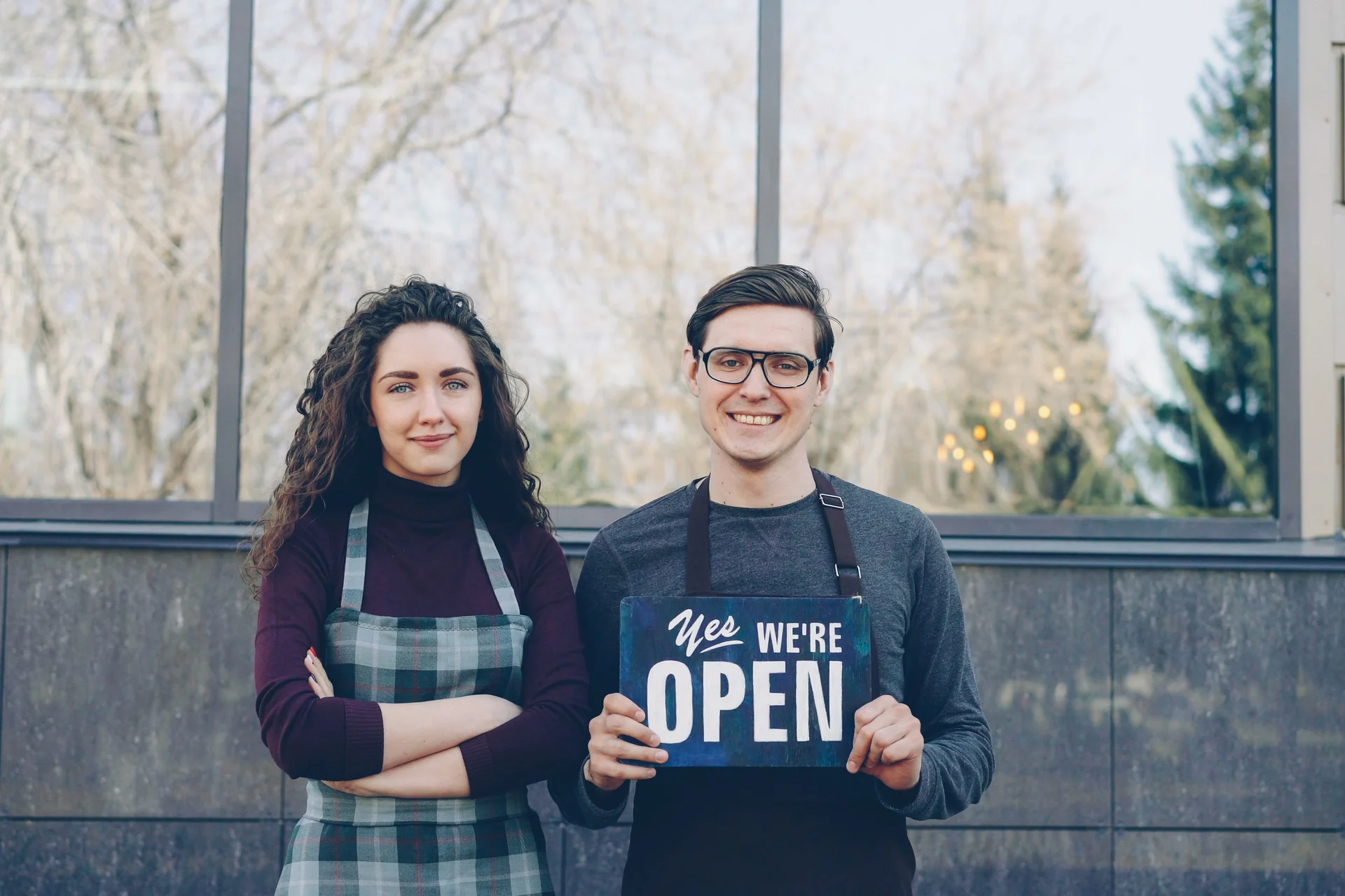 Small business owners displaying an open sign