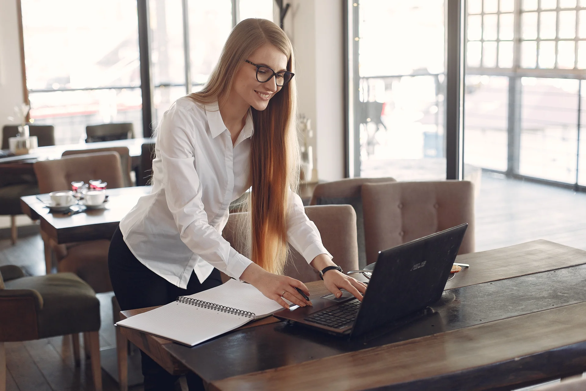 A businesswoman working on a laptop in a café